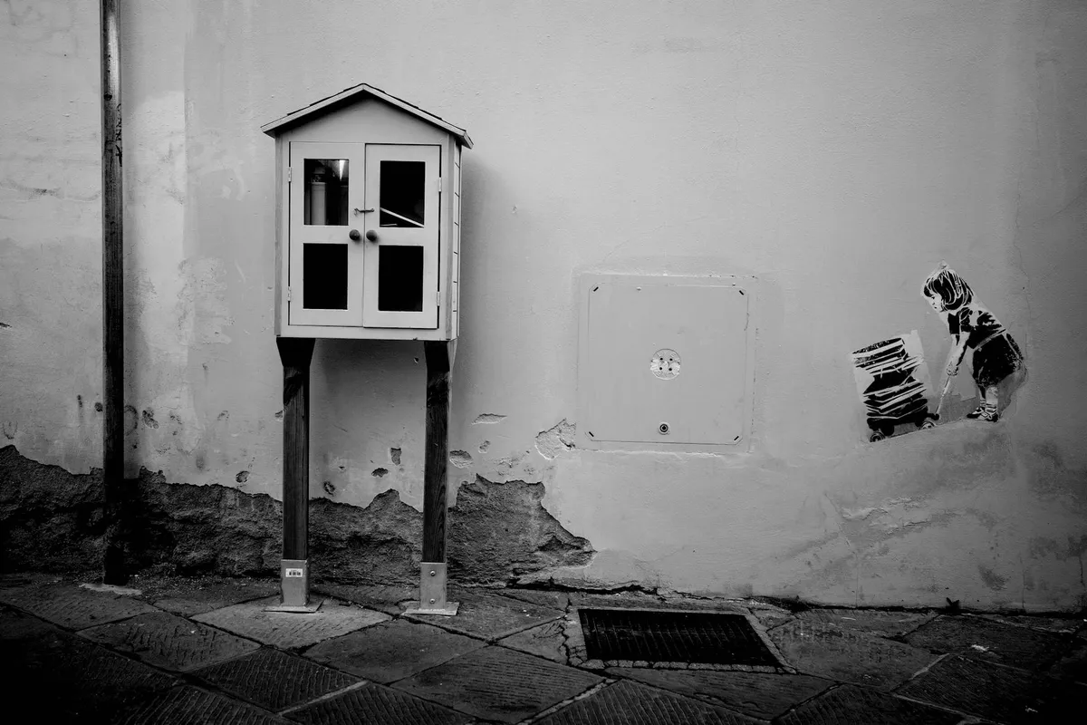 A stencil street art piece on an urban wall